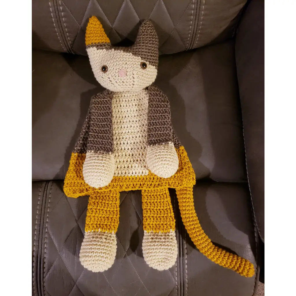 Crocheted cat-like stuffed toy with gray, yellow, and white yarn.