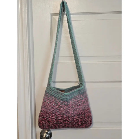 Crocheted shoulder bag with an ombre effect from mint green to pink.