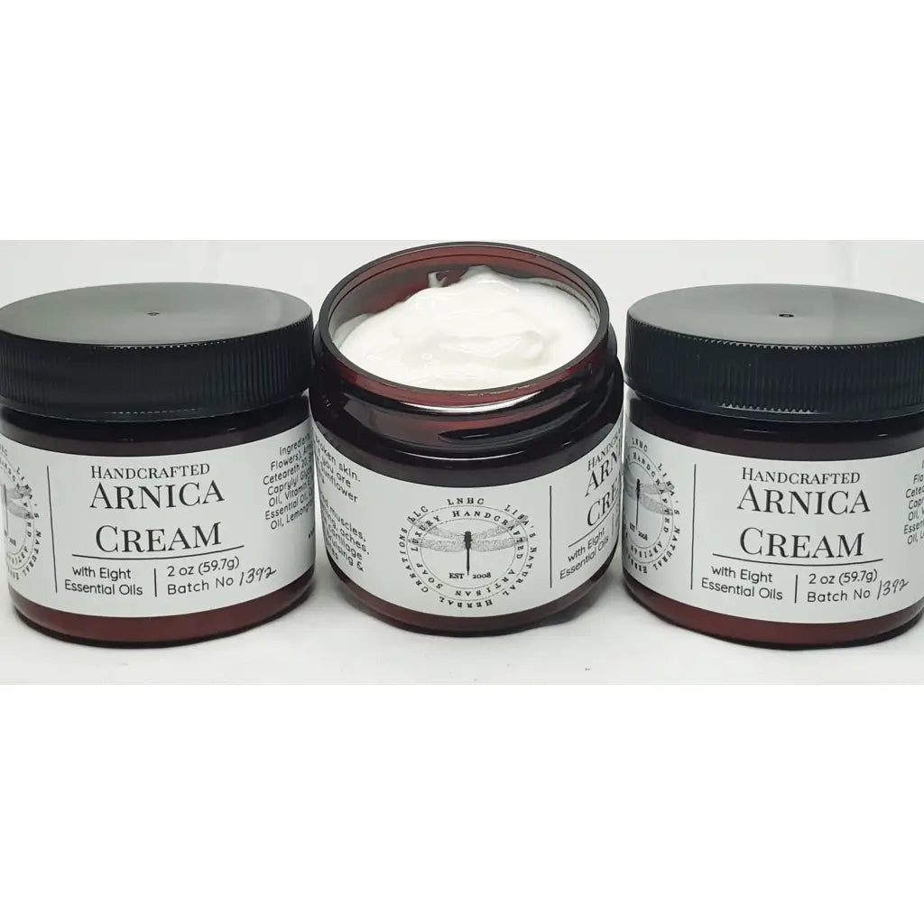Jars of handcrafted arnica cream with black lids and labels.