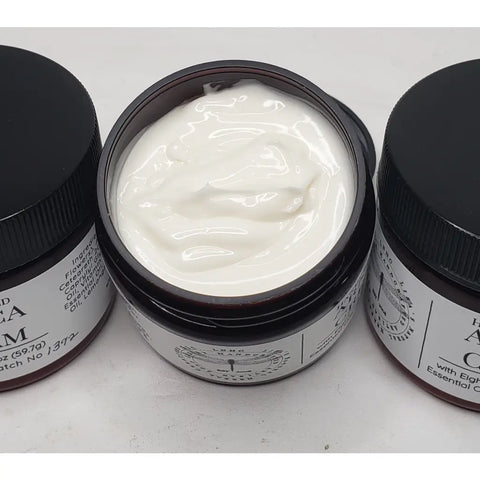 Jars of handcrafted arnica cream with black lids and labels.