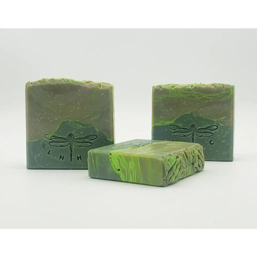 Handmade green soap bars with dragonfly imprints.