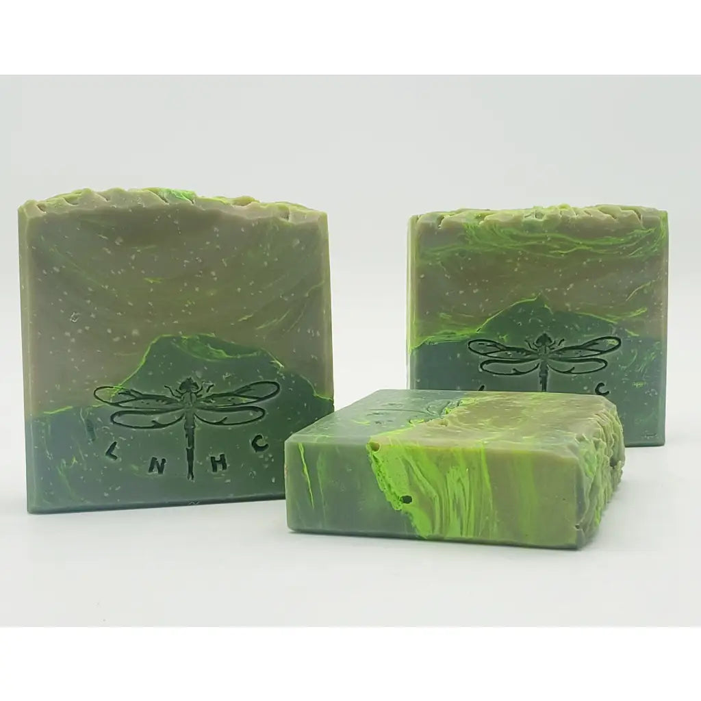 Handmade green soap bars with dragonfly imprints.