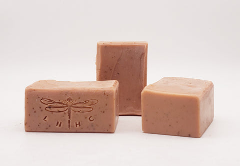 Pink handmade soap bars with dragonfly imprints.
