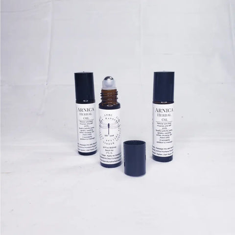Three bottles of Arnica herbal oil with dropper caps.