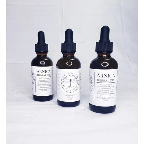 Three bottles of Arnica herbal oil with dropper caps.
