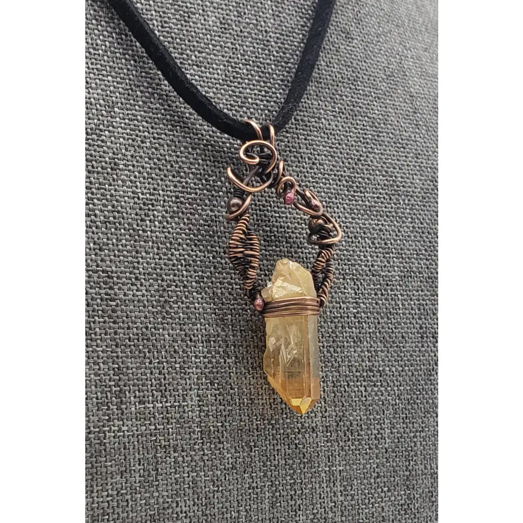 Crystal pendant necklace with intricate wire wrapping and a black cord.
