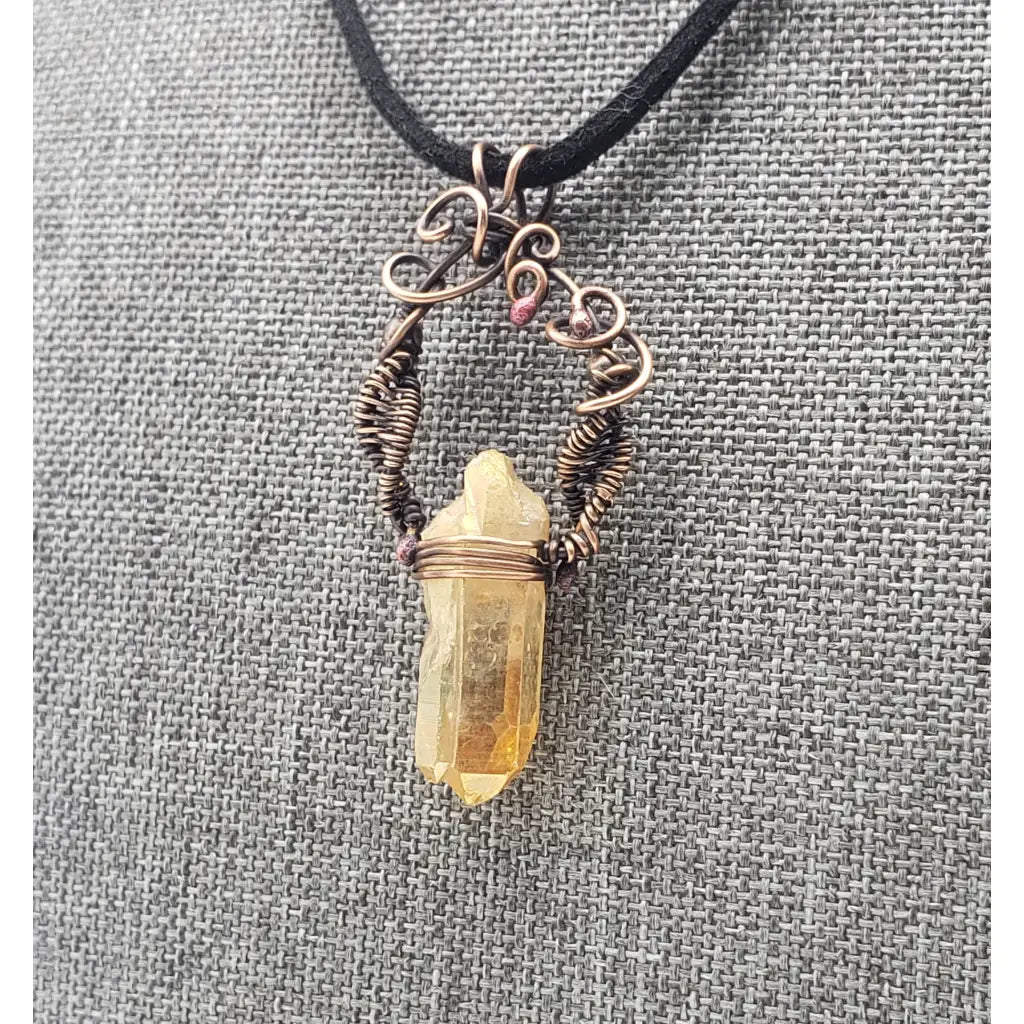 Crystal pendant necklace with intricate wire wrapping and a black cord.