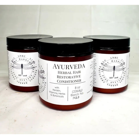 Ayurvedic herbal hair restorative conditioner in amber jars with black lids and white labels.