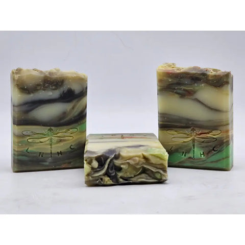 Handmade artisanal soap bars with swirled patterns and dragonfly designs.