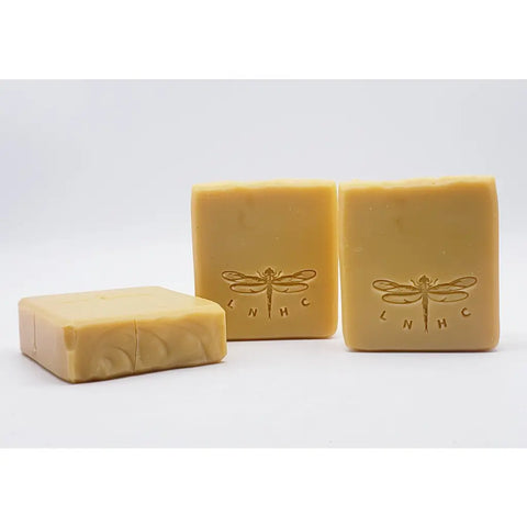 Handmade soap bars with dragonfly designs stamped on them.