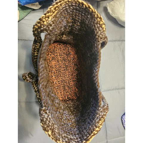 Crocheted brown tote bag with spiral shell-like decorations in lighter shades.