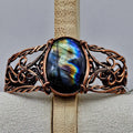 Copper wire wrapped cuff bracelet with a large labradorite cabachon with flashy labradorescence. celtic braided style copper work