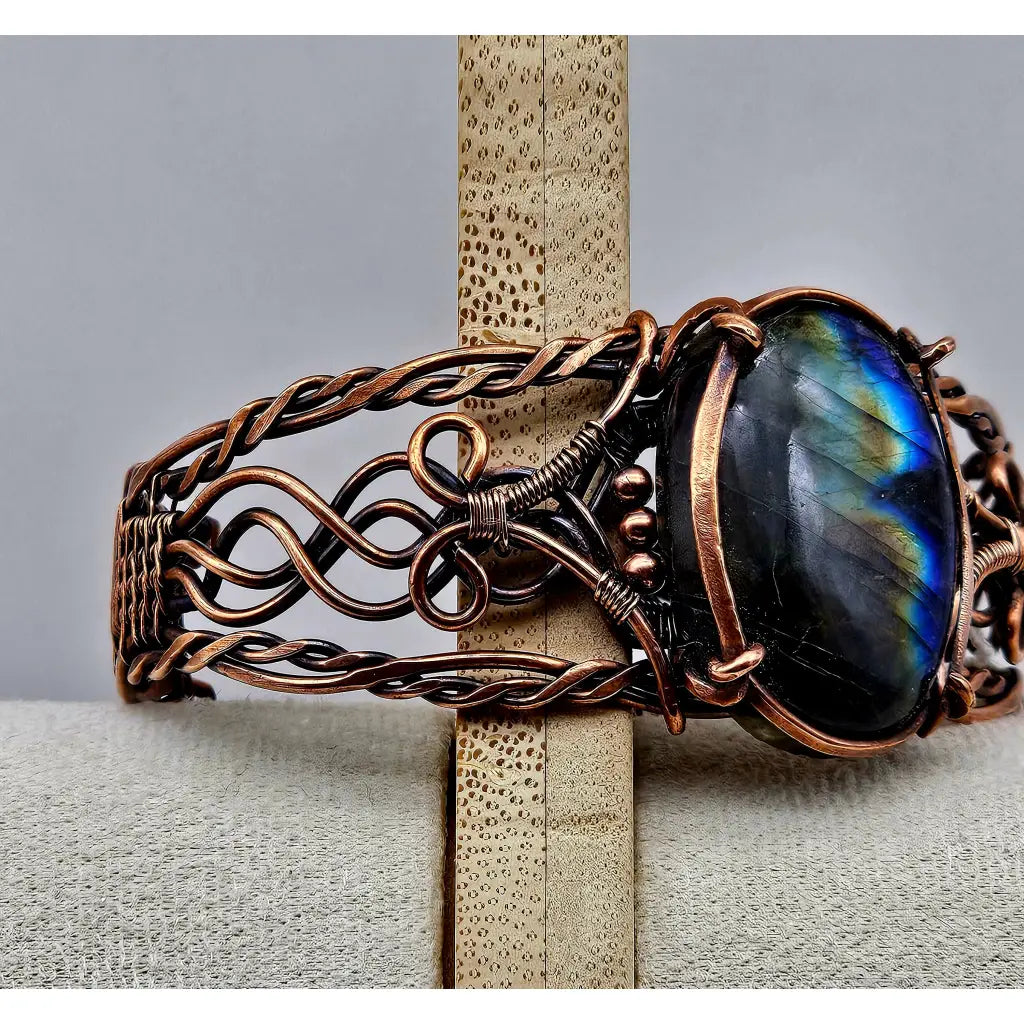 Copper wire wrapped cuff bracelet with a large labradorite cabachon with flashy labradorescence. celtic braided style copper work