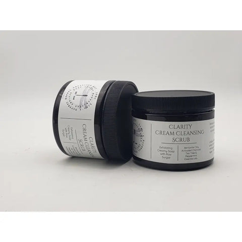 Jars of Clarity Cream Cleansing Scrub skincare product stacked in a pyramid formation.