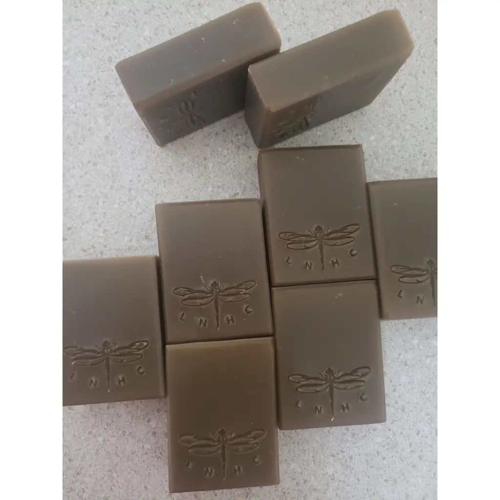 Bars of handmade soap with dragonfly designs stamped on them.