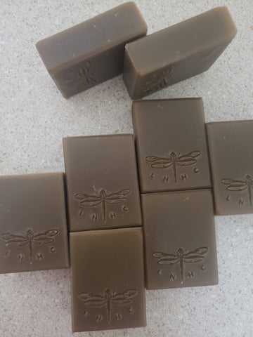 Bars of handmade soap with dragonfly designs stamped on them.