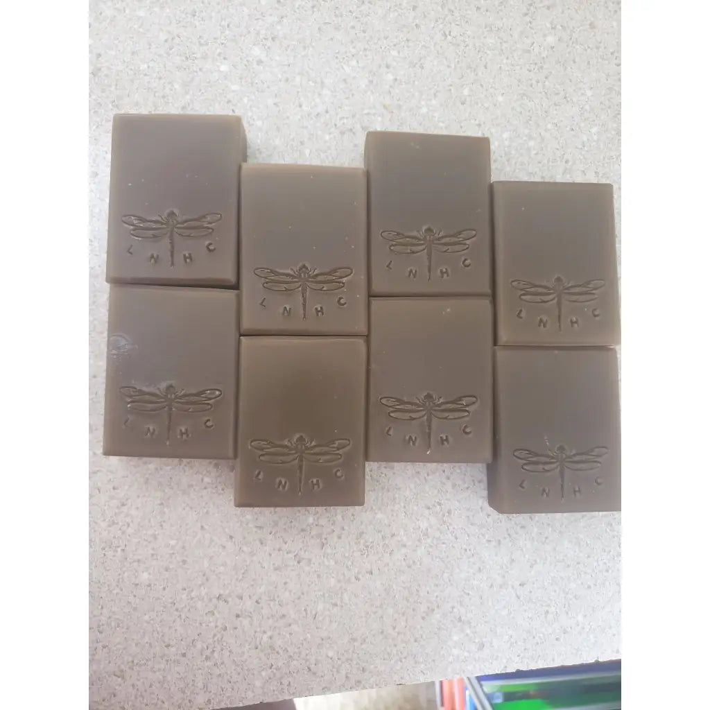 Bars of handmade soap with dragonfly designs stamped on them.