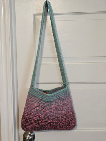 Crocheted shoulder bag with an ombre effect from mint green to pink.