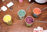 Colorful liquid paints with stirring sticks for soap challenge inspired by oatmeal milk and shea butter