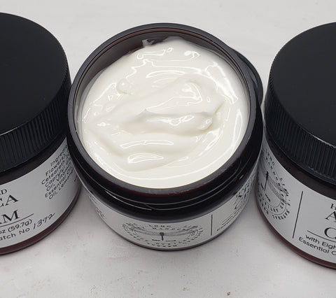 Jars of handcrafted arnica cream with black lids and labels.