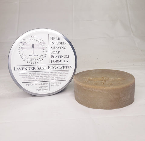 Circular tin containing a round bar of soap with a dragonfly imprint.
