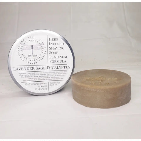 Circular tin containing a round bar of soap with a dragonfly imprint.