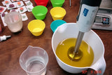 Immersion blender mixing golden liquid for soap challenge with oatmeal milk and shea butter