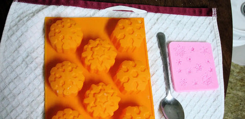 Orange and pink silicone molds with flower and snowflake shapes for Mauna Kea soap challenge