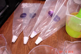 Pastry bags with piping tips and colorful contents for soap challenge featuring oatmeal milk and shea butter