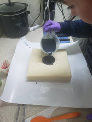 Pouring dark liquid into a square mold for acrylic string pull natural herbal creations lapis blue