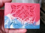 Pink, white, and blue carved soap with snowflake design using craft knife and wood chip carving