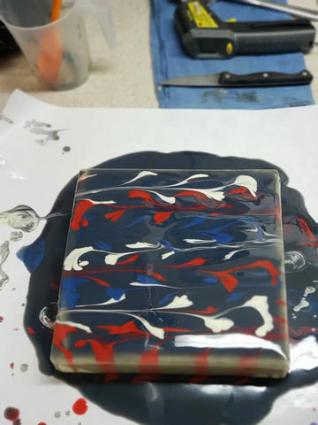 Acrylic string pull resin block with swirled red, white, and lapis blue patterns