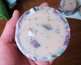 Round rimmed soap with colorful embedded wax pieces and dark speckles for Soap Challenge