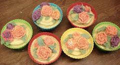 Seven flower-decorated desserts in colorful fluted cups for Oatmeal Milk & Honey Soap Challenge