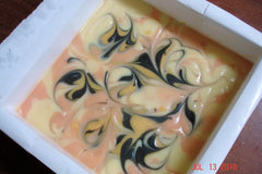 Swirled multicolored soap batter in a white slab mold for Almond & Honey Pipe Swirl Soap Challenge
