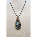 Handmade wire wrapped Labradorite & Red Brass pendant on a cord. High labradorescense showing on the labradorite. Scrolling Brass Braided wire with a hematite accent bead. Front view on a beige display form.