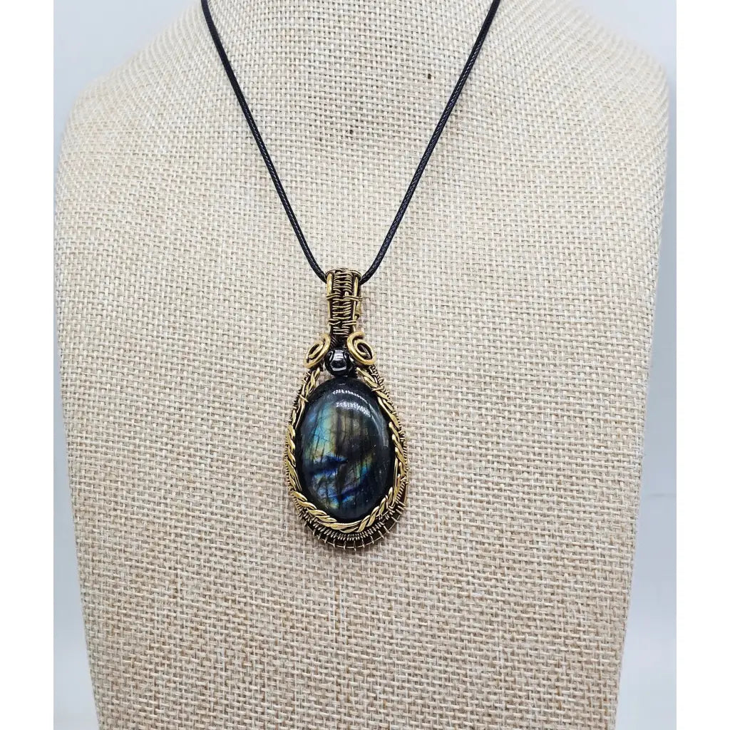 Front view, Handmade wire wrapped Labradorite & Red Brass pendant on a cord. High labradorescense showing on the labradorite. Scrolling Brass Braided wire with a hematite accent beadront view, 