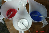 Colorful liquid in pitchers with forks for carved soap and wood chip carving craft knife project