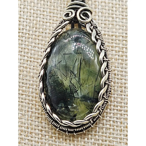 Oval tourmalinated prehnite pendant in sterling silver wire wrapping